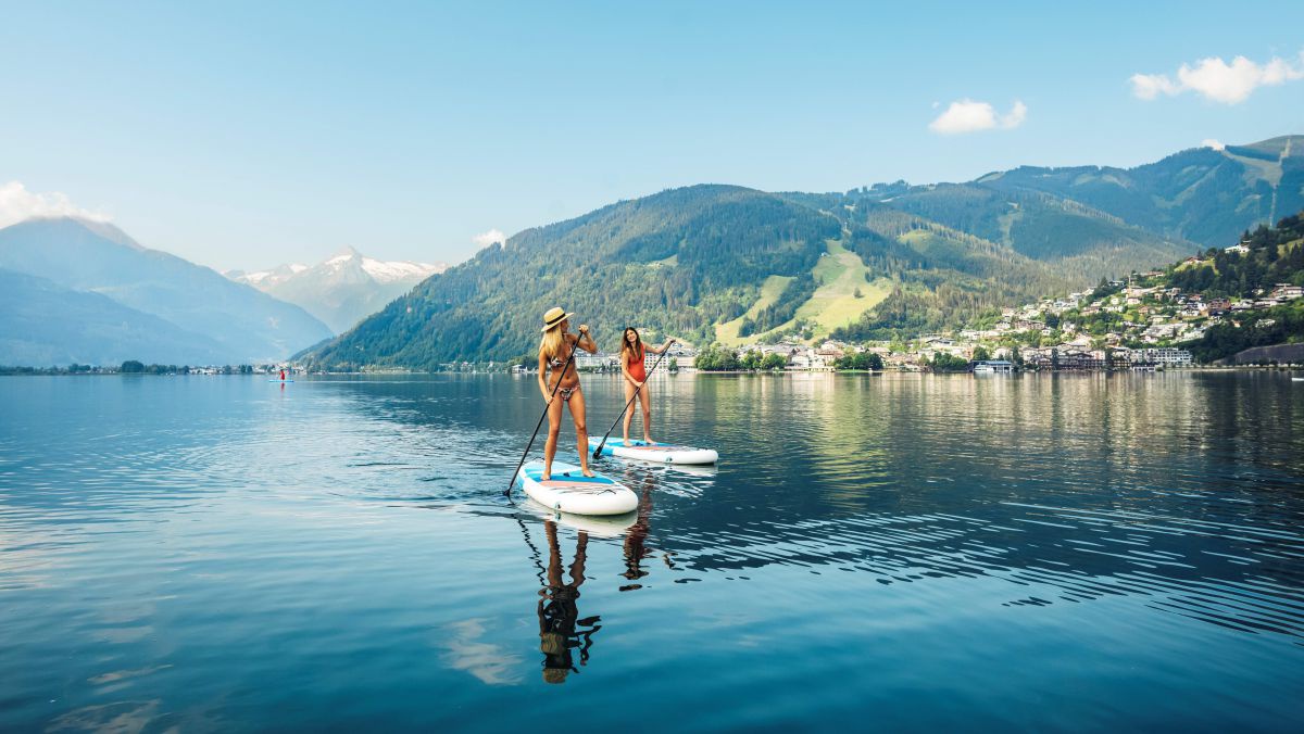 2 Frauen auf Stand-up-Paddels am See.