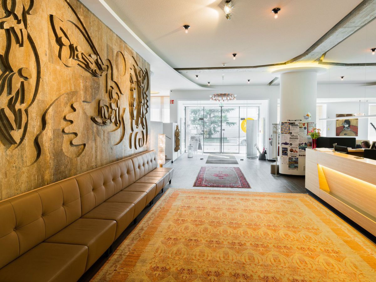 Rezeption, links die Steinwand mit Ornamenten.