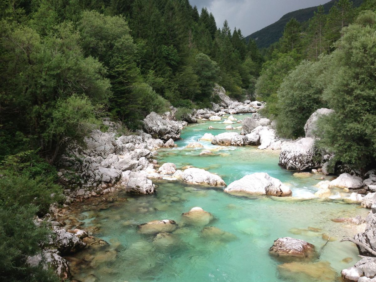 Smaragdgrüner Fluss, im Flussbett viele große Steine.