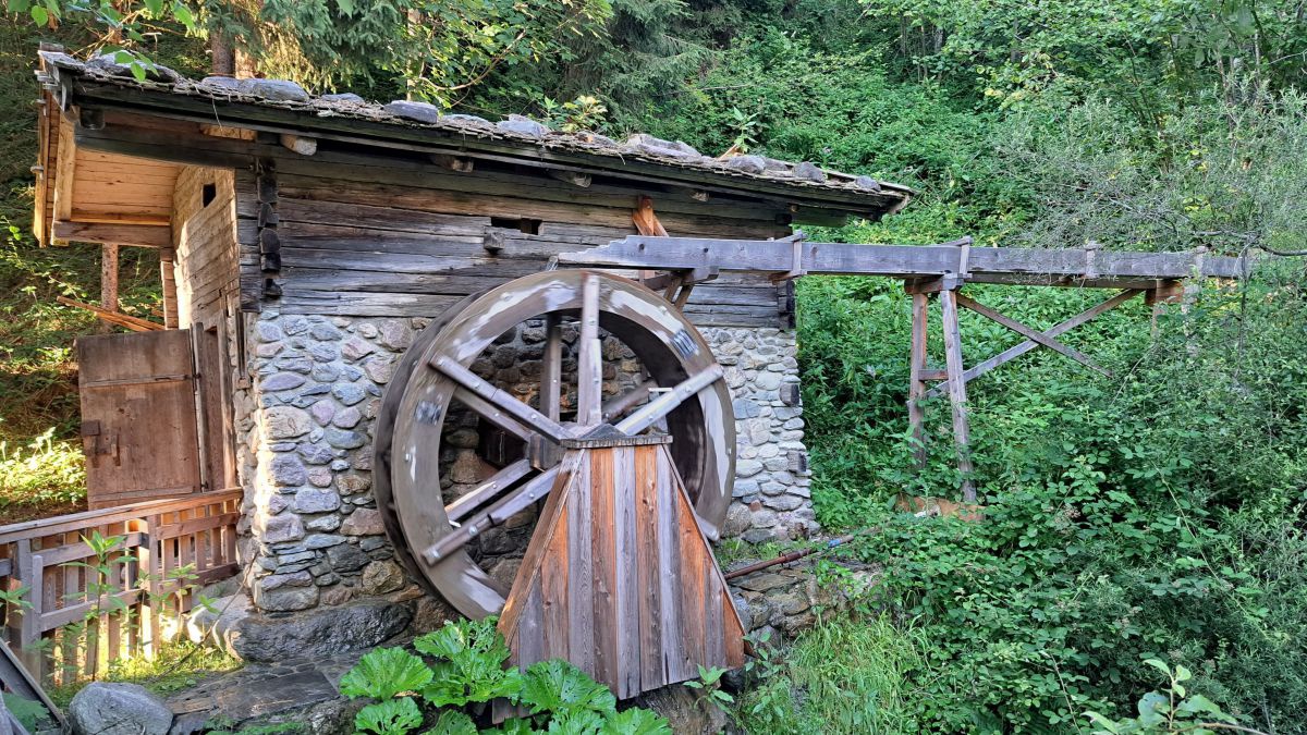 Steinhaus mit hölzernem Mühlrad.