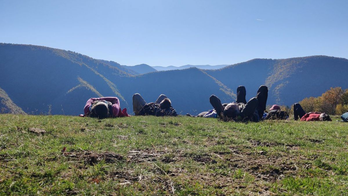Leute liegen auf einer Anhöhe im Gras.