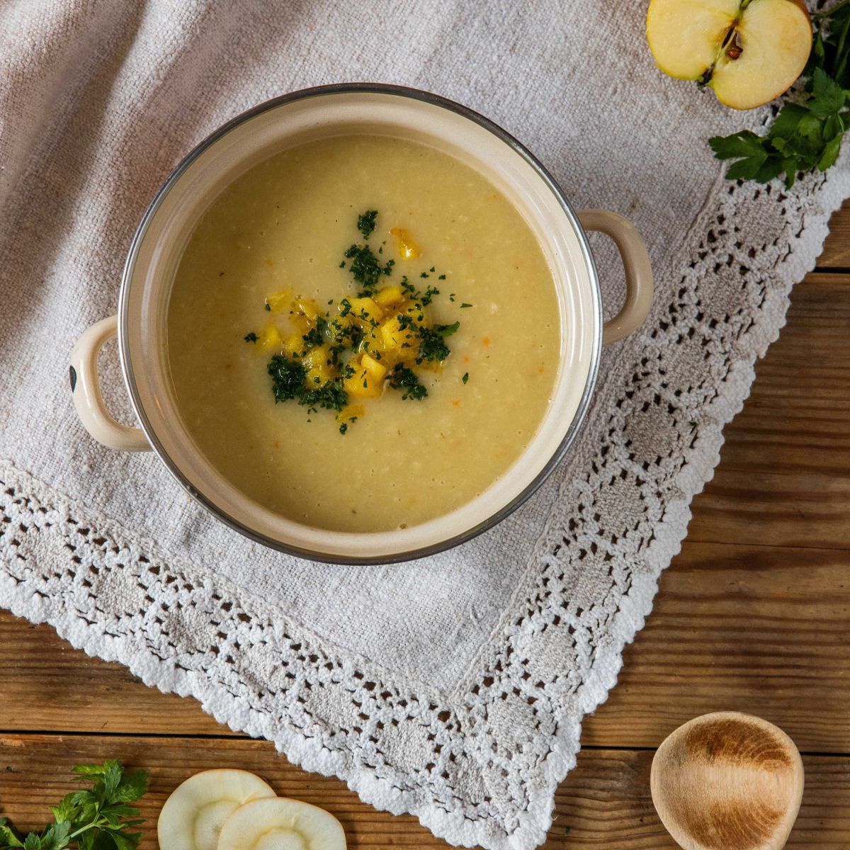 Gelbe suppe mit grünen Kräutern drauf.