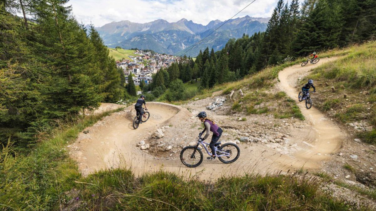 Vier Biker auf einer Abfahrt in einer scharfen Kurve.