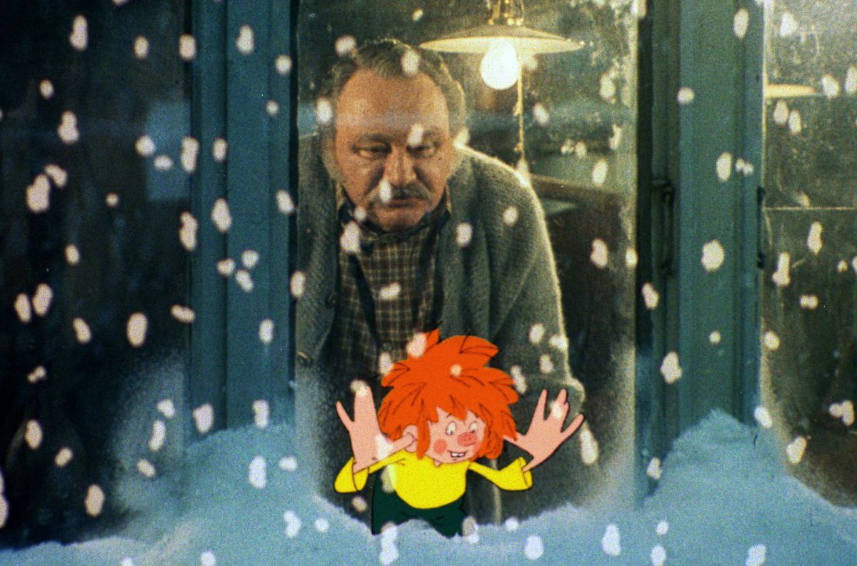 Meister Eder un Pumuckl blicken aus dem Fenster, draußen schneit es.