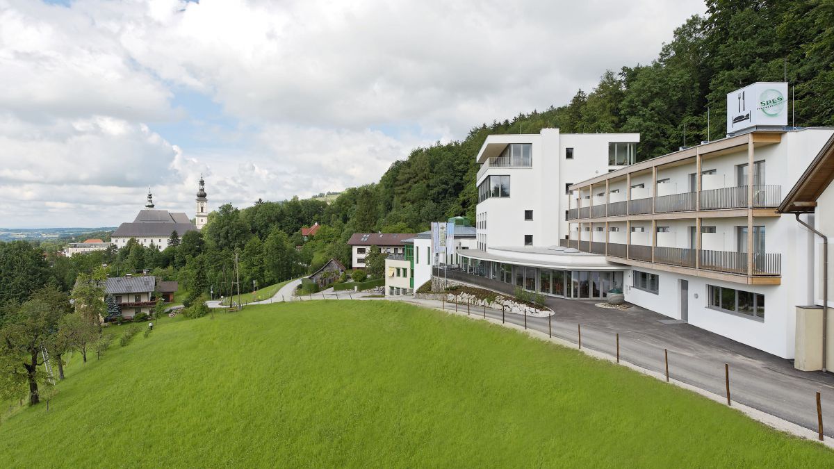 Aussenansicht des Seminarhauses mit schlichten geraden Formen, im Hintergrund der Turm des Stiftes Schlierbach.