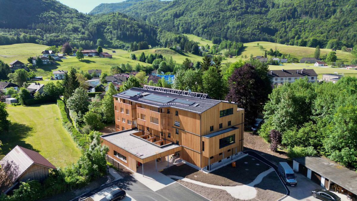 Hotel mit Holzfassade aus der Luft fotografiert.