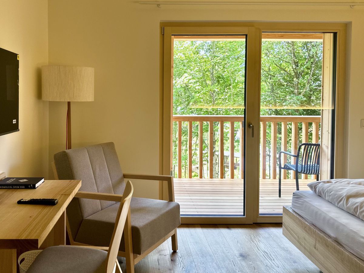 Schlicht eingerichtetes Zimmer mit Balkon 