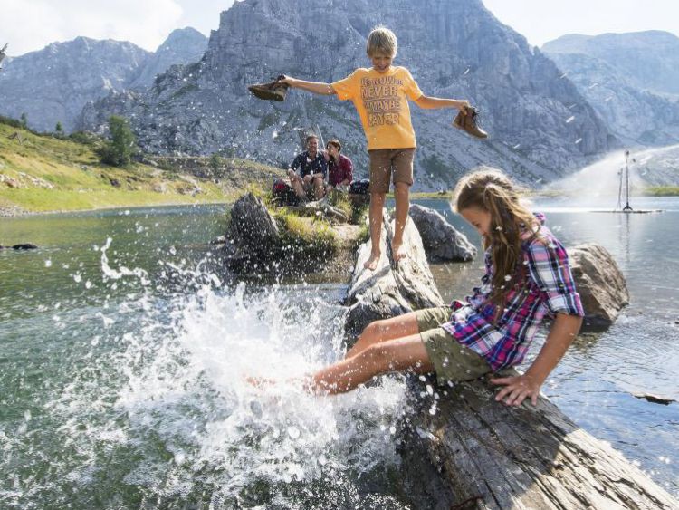 Kinder plantschen mit dem Bergwasser