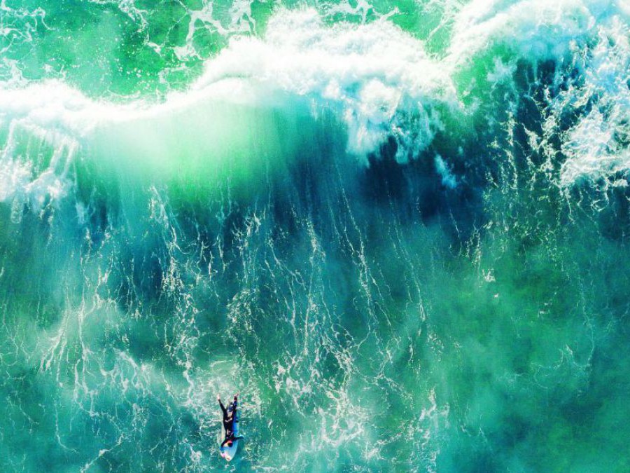Surfer auf dem Meer, von hoch oben fotografiert.