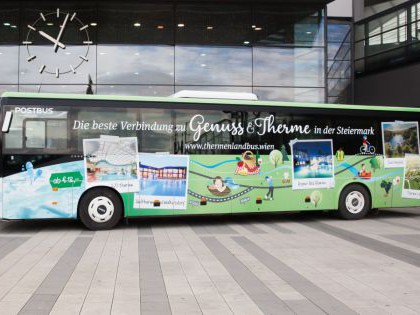 Grün bemalter Bus mit Bildern der einzelnen Thermen vor dem Wiener Hauptbahnhof.